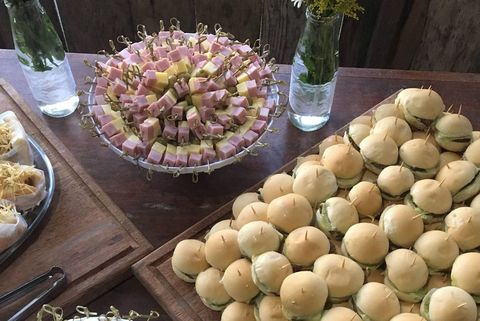 Mesa de finger food com mini hambúrgueres e espetinhos para confraternização de empresa na Grande Florianópolis