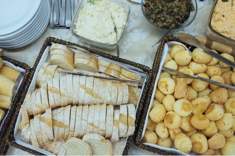 Pães fatiados e pão de queijo no buffet