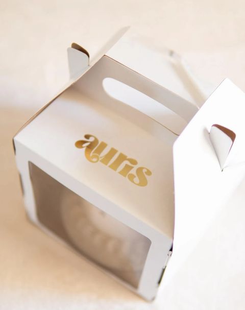 Caixa branca da Auris Doceria com logo dourado, pronta para transportar o bolo – Auris Doceria